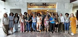 Homens e mulheres posam para a foto em frente ao Centro de Memória do TRE-MG