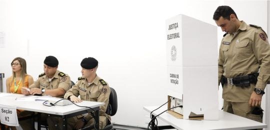 Wellerson Amarante, secretário de TI do TRE-MG, durante palestra. Junto dele há um telão com inf...